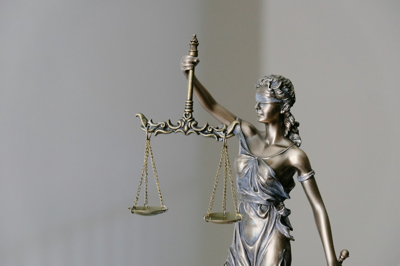 A bronze Lady Justice statue holding scales