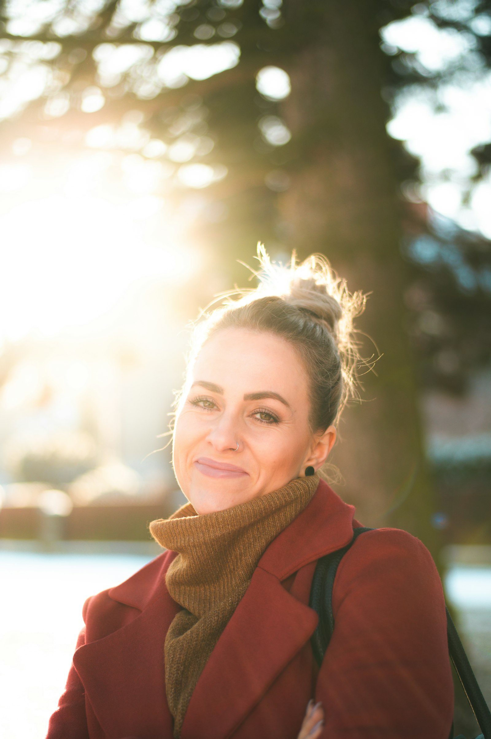 A smiling woman outdoors in warm sunlight